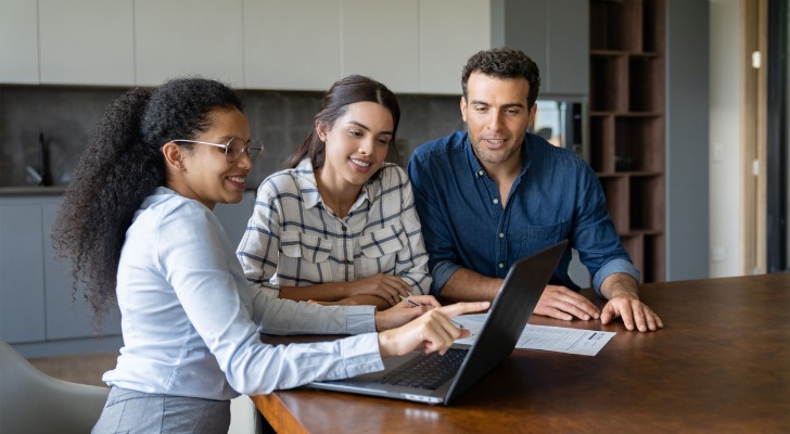 A couple calculating the NOI of an investment property with a financial advisor.